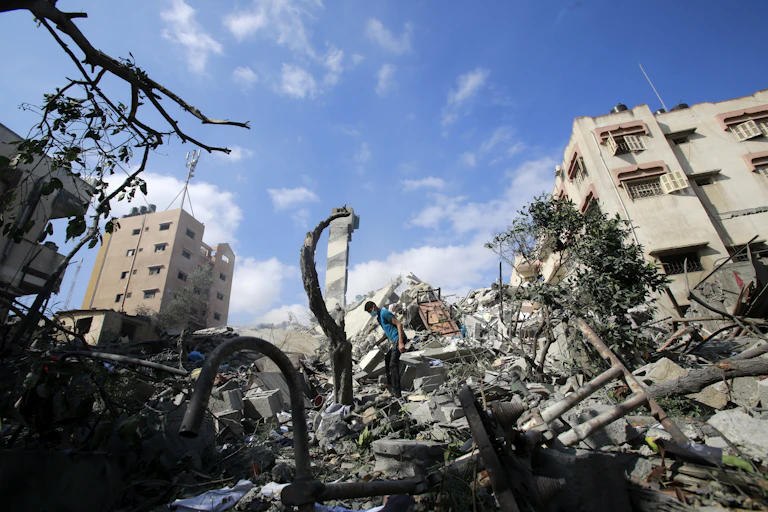 A boy stands atop charred ruins
