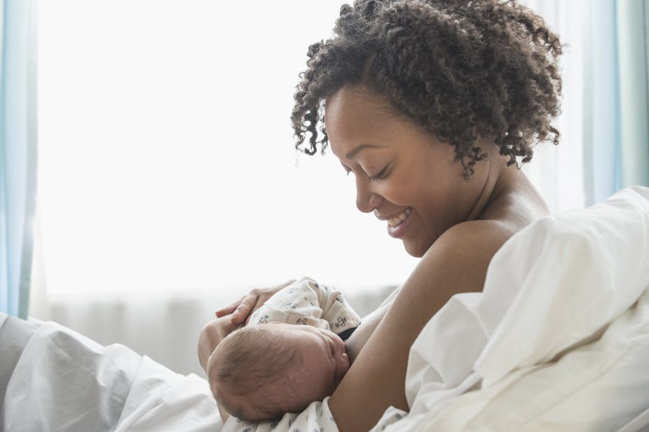 A woman breastfeeds her baby.