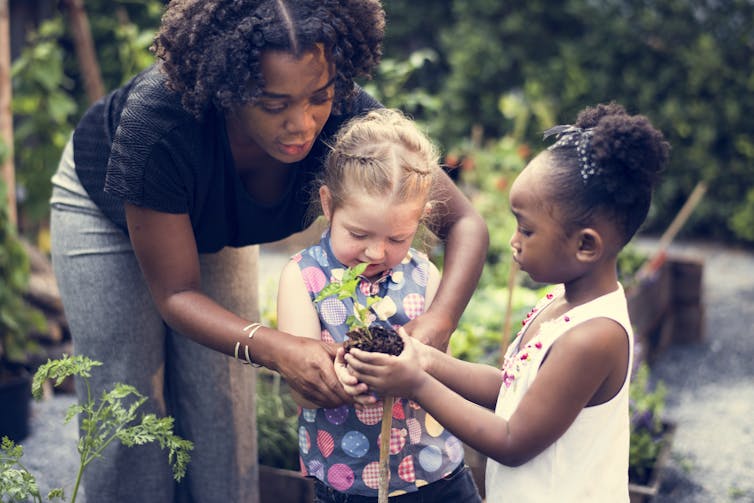 A teacher and kids at a garden.