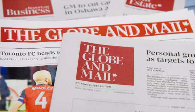 Des copies du quotidien The Globe and Mail sont étalées sur un bureau.