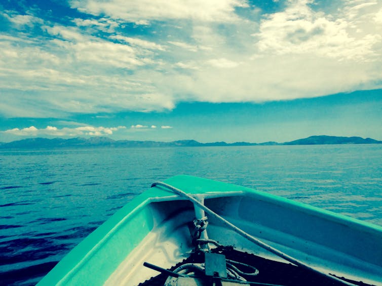 View looking over the bow of a boat on open water.