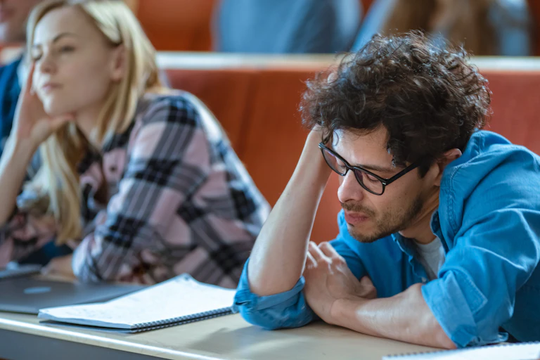 bored students with heads on hands as they listen to lecture