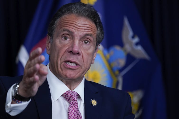 Andrew Cuomo in front of flag