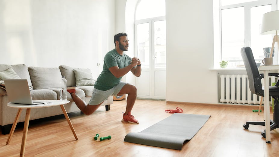Man performs a split squat using his couch.