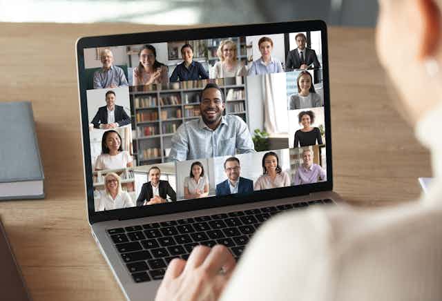 Laptop screen showing online meeting with colleagues.