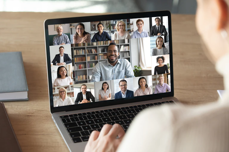 Laptop screen showing online meeting with colleagues.