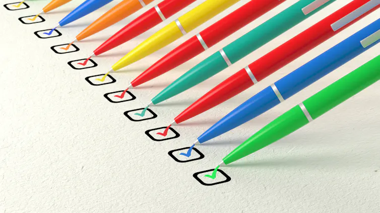 A line of different coloured pens ticking boxes.