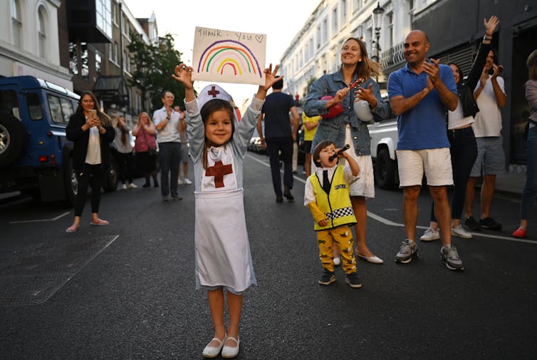 A girl in a nurses outfit applauds during the Clap For Our Carers campaign in support of the National Health Service.