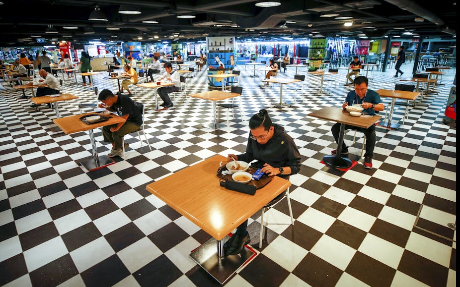 Socially distanced diners eat a food-court in Bangkok.