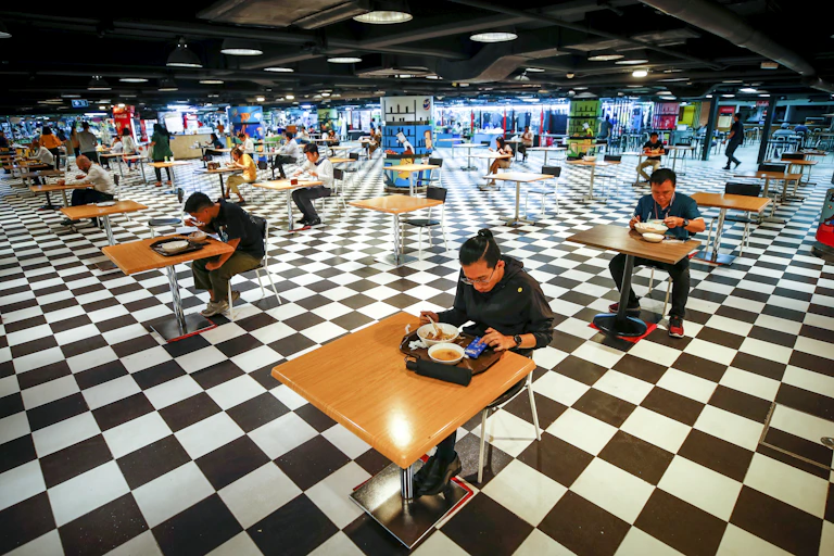 Socially distanced diners eat a food-court in Bangkok.