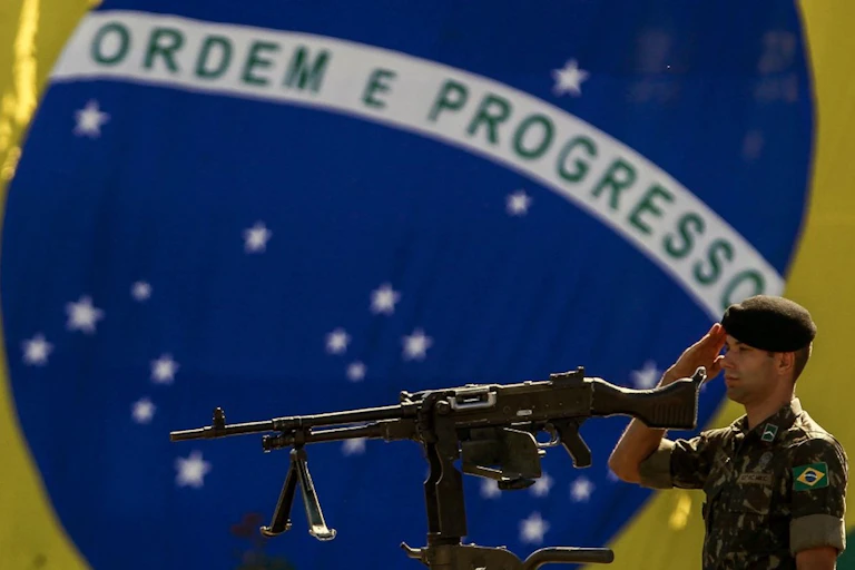 Un soldat de l'armée brésilienne monte la garde devant un drapeau national brésilien lors d'une cérémonie pour marquer la Journée de l'armée, à Sao Paulo, au Brésil, le 18 avril 2019.