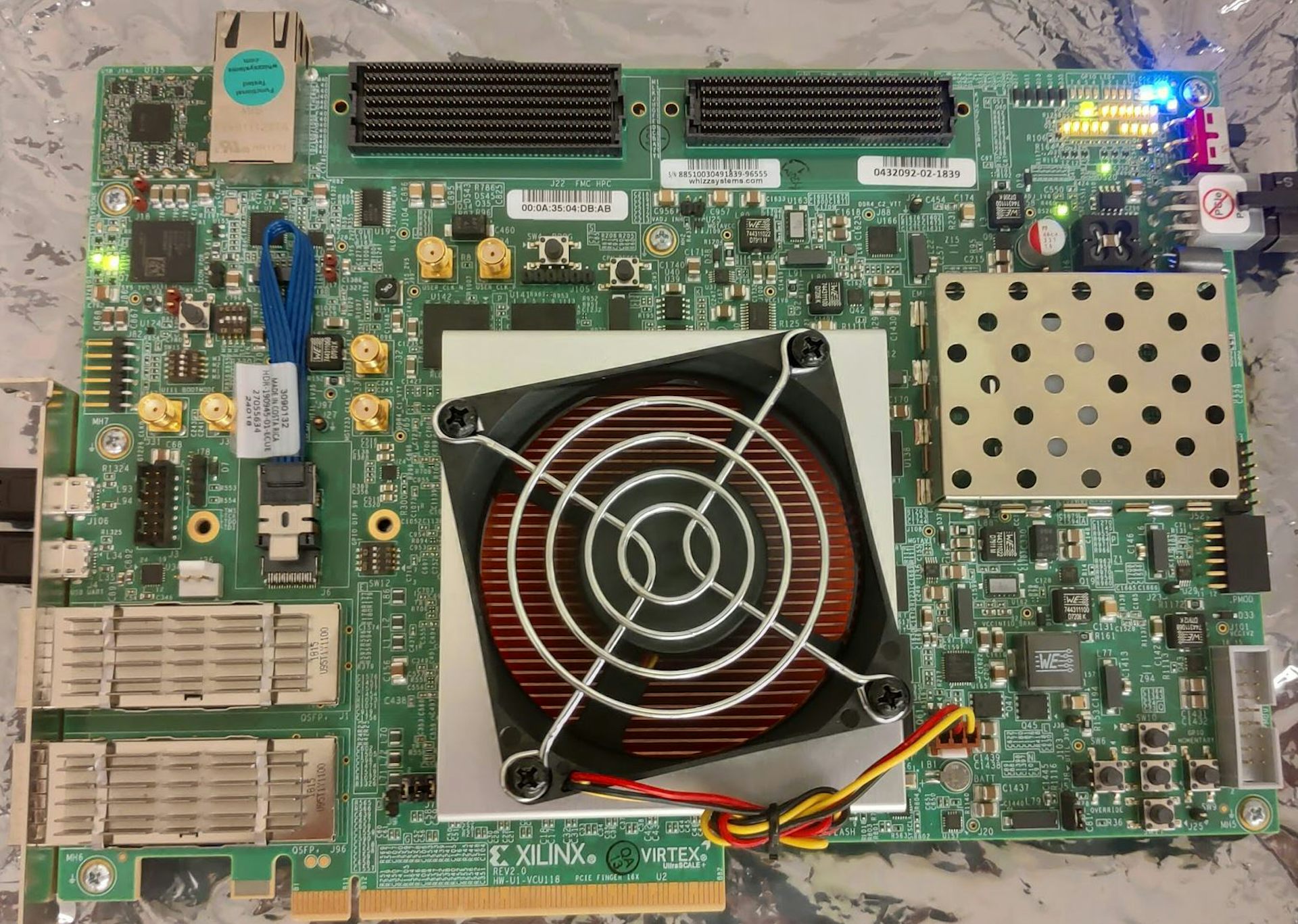 A fan on top of a metal square in the middle of a computer circuit board