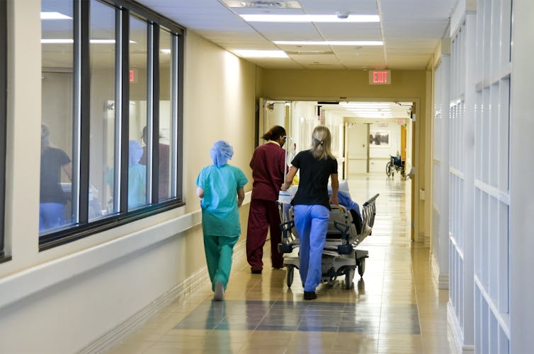 Doctors rushing patient through hospital corridor