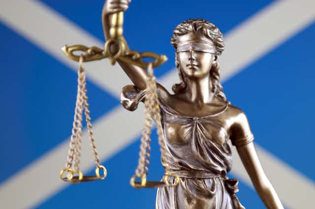 Image of the scales of justice against the Saltire flag.