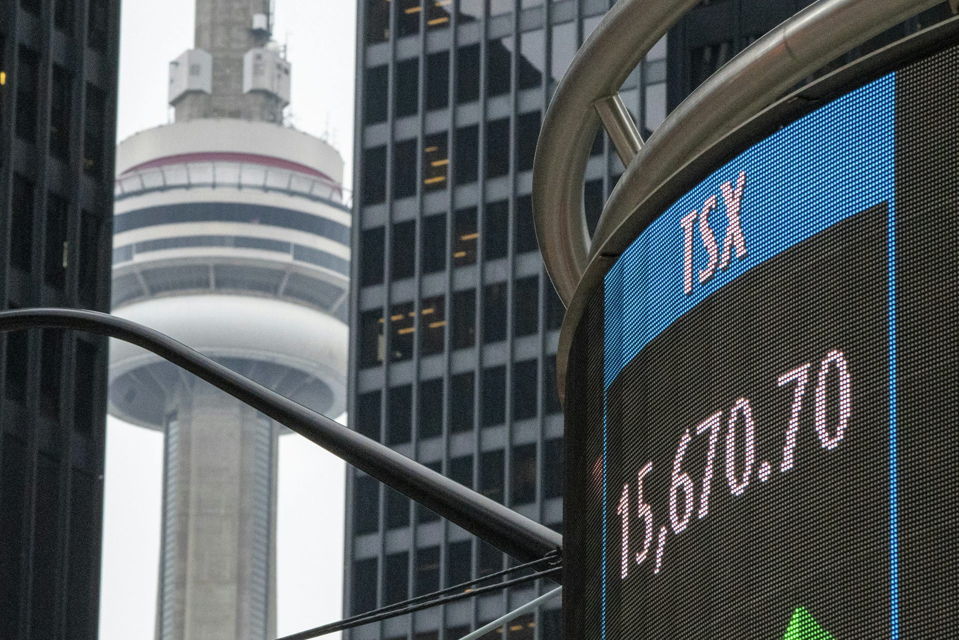 A sign board in Toronto shows the closing number for the TSX with the CN Tower in the background.