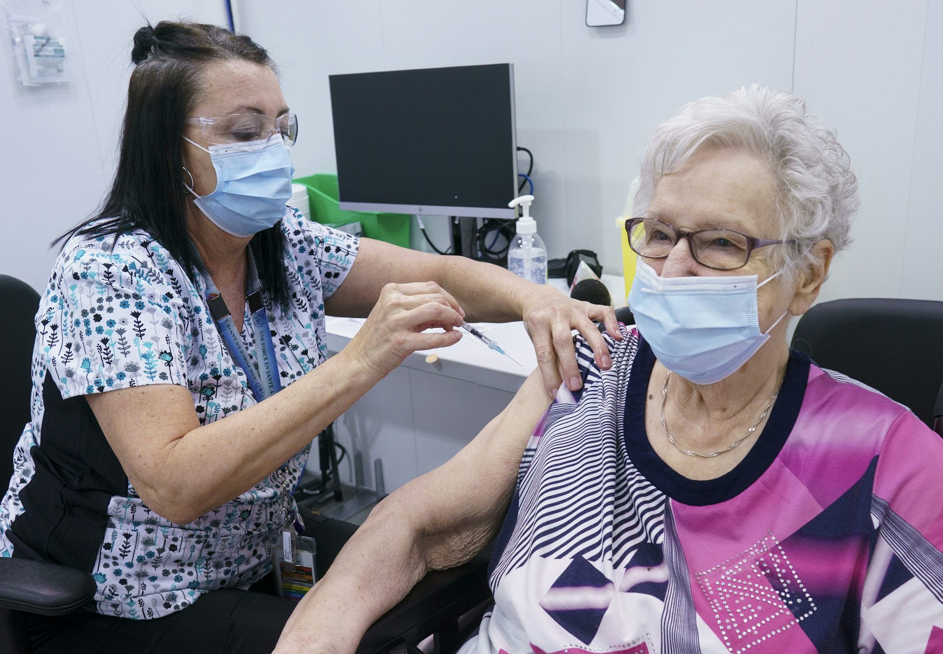 Infirmière en train de vacciner une dame âgée