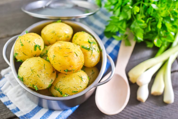 A bowl of boiled potatoes with fresh dill on top.