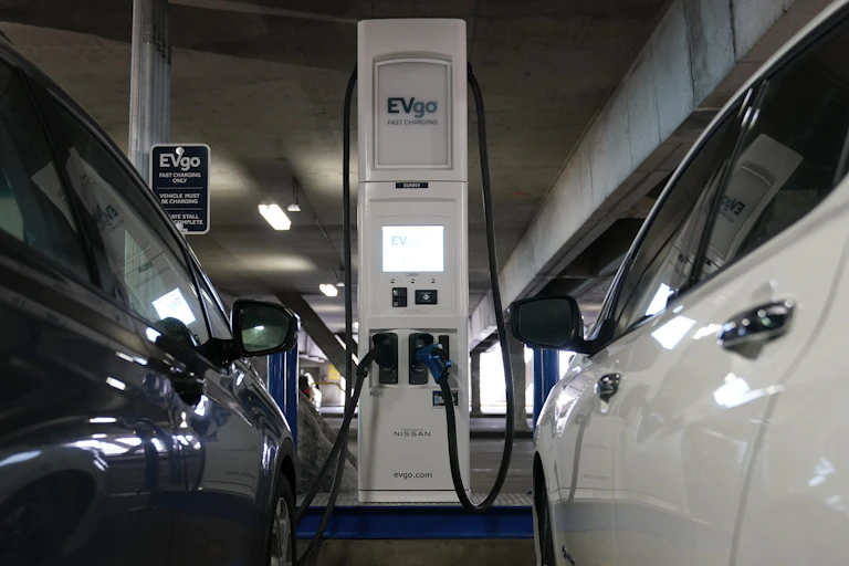 Two electric cars charging in a train station garage.