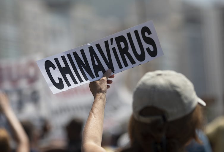 Person holds sign that reads 'CHINAVIRUS'