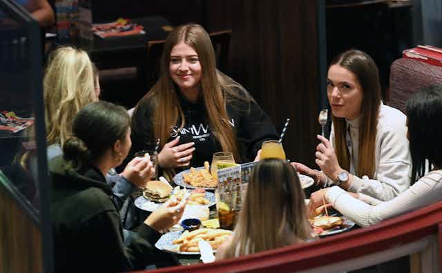 A group of friends having a meal indoors at a pub