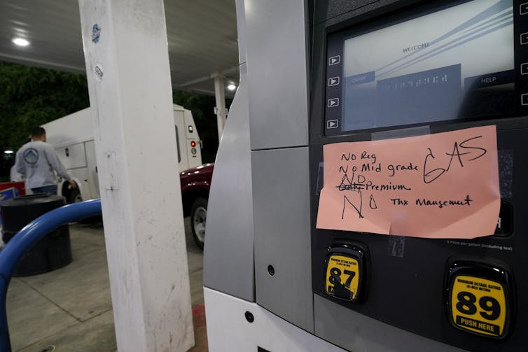 A handwritten sign posted on a gas pump showing that the service station is out of all grades of fuel