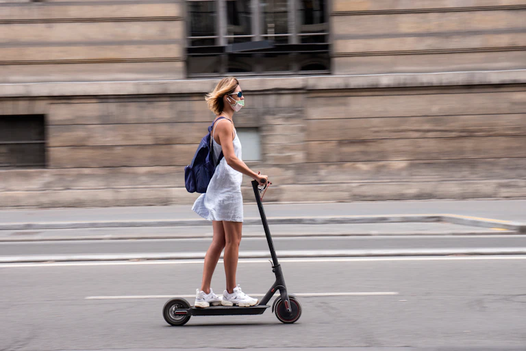 Femme circulant en trottinette électrique