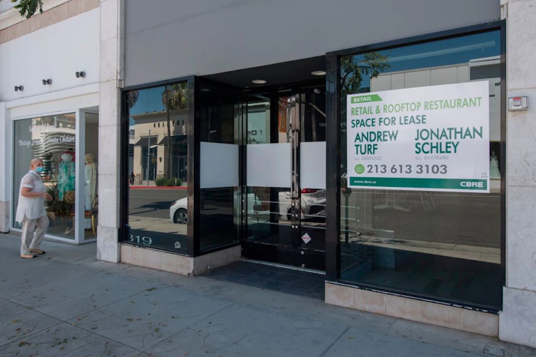 People walk past empty stores and restaurants closed due to impact of Covid-19 in Beverly Hills, California