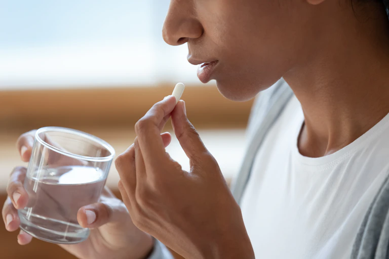 Young person taking antidepressant pill
