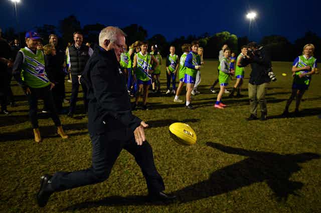 Scott Morrison, kicking an AFL ball