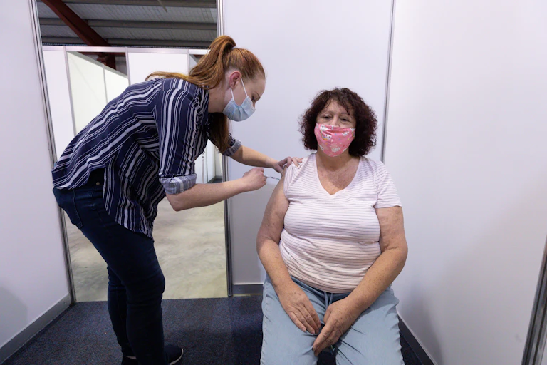 A woman receives a vaccination.