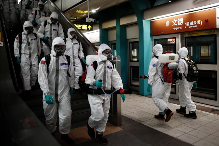 Military workers spraying disinfectant in a train station in Taiwan