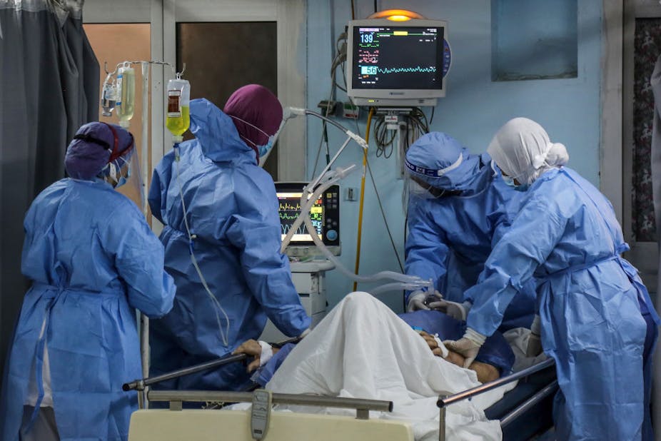 Doctors and nurses adjust the oxygen mask of a COVID-19 patient inside the Intensive Care Unit of Heliopolis hospital, Egypt