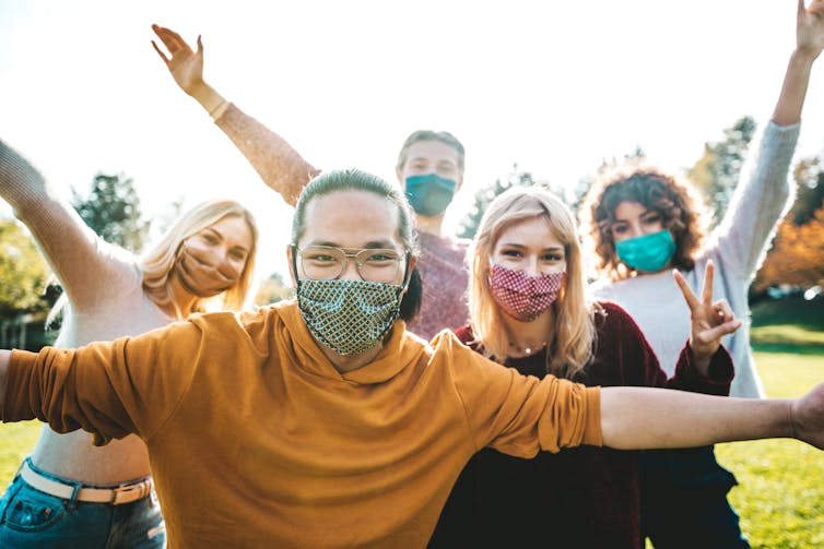 People wearing face masks outside socialising