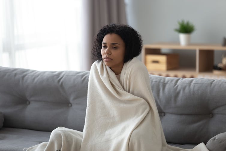 An ill woman wrapped in a blanket