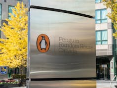 Logo of a penguin at Penguin Random House Canada office on a silver post outdoors.