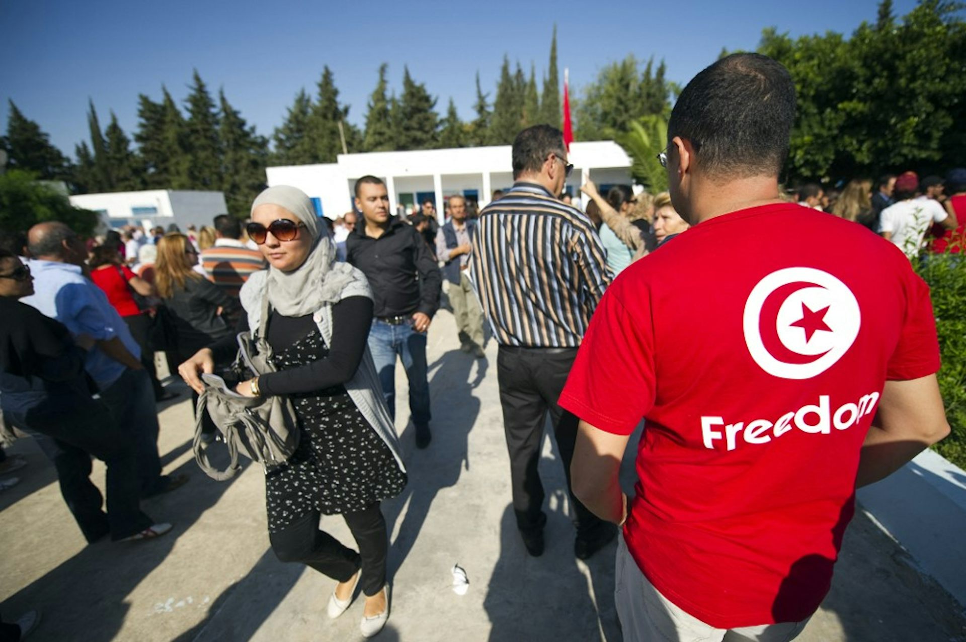 People gather outside a polling station in Tunisia on October 3, 2011