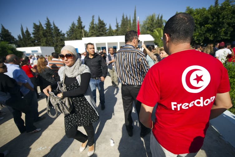 People gather outside a polling station in Tunisia on October 3, 2011