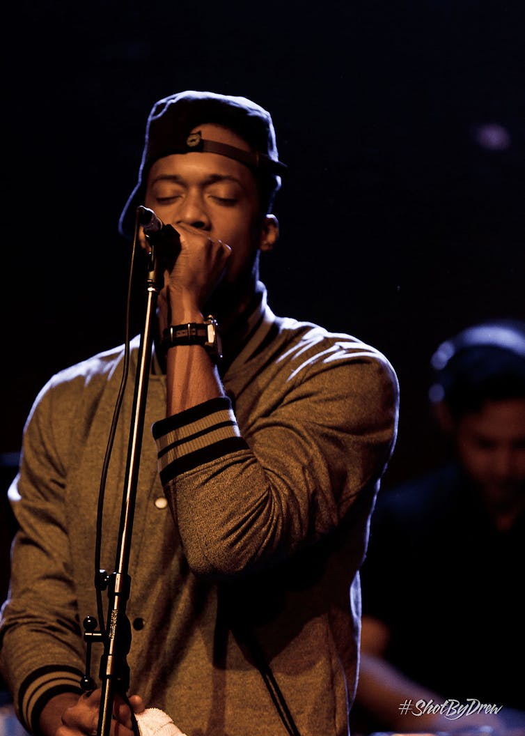 A young African American artist performs on stage.