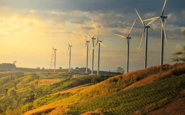 Wind turbines on a hill at sunset