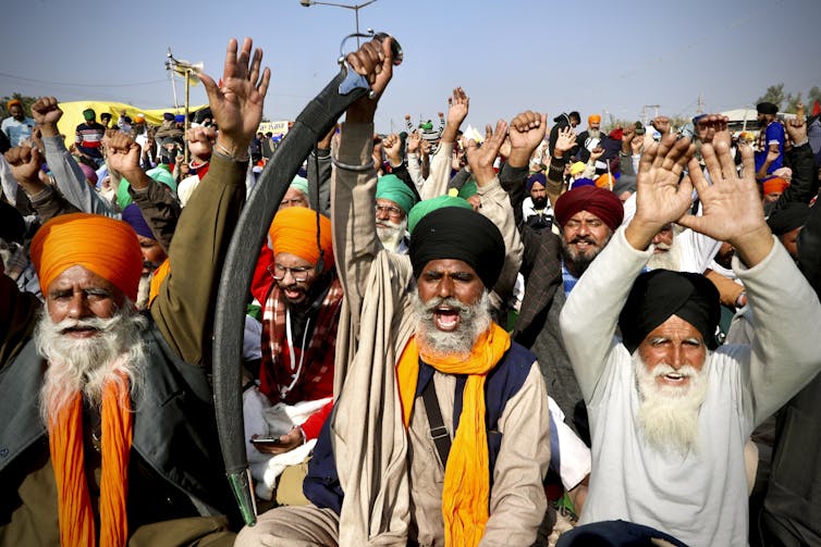 Men in colourful turbans shout