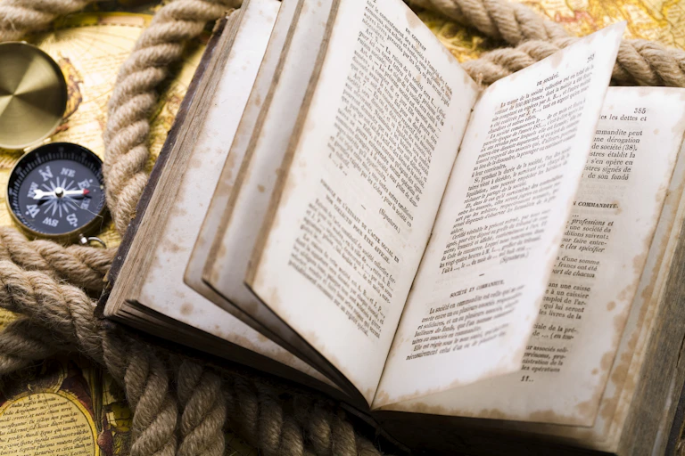 A world map and on it a large rope, campus and an open book.