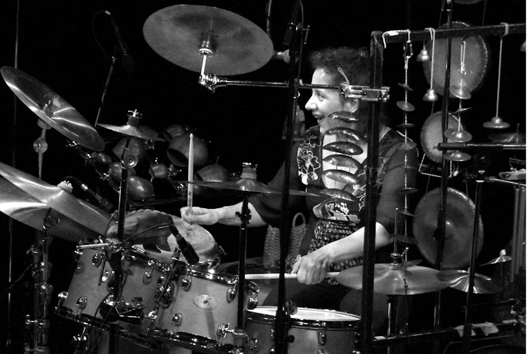 Woman plays a large selection of percussion instruments.