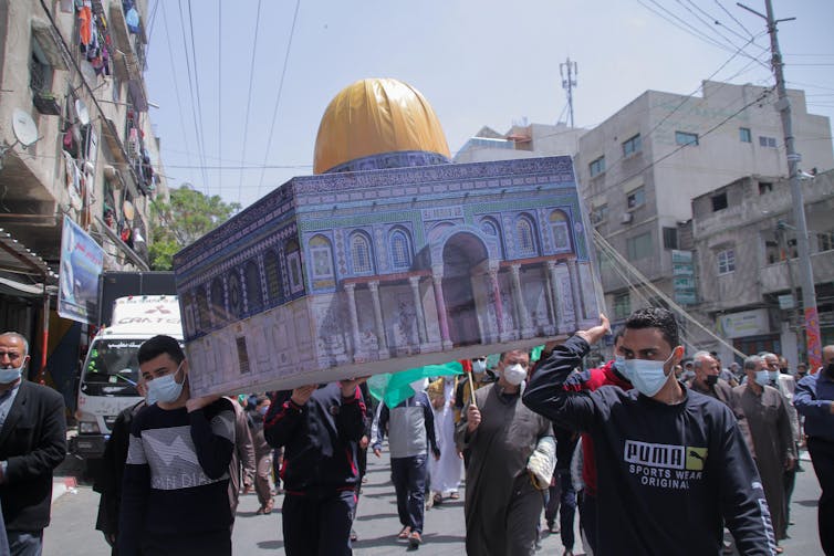 Palestinian protesters carry an effigy of the Al-Aqsa mosque during a demonstration in Gaza in April