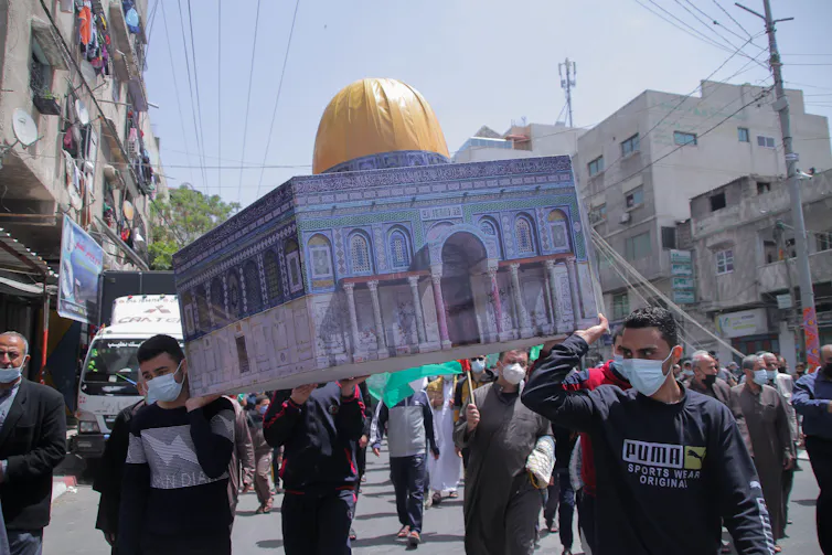 Palestinian protesters carry an effigy of the Al-Aqsa mosque during a demonstration in Gaza in April