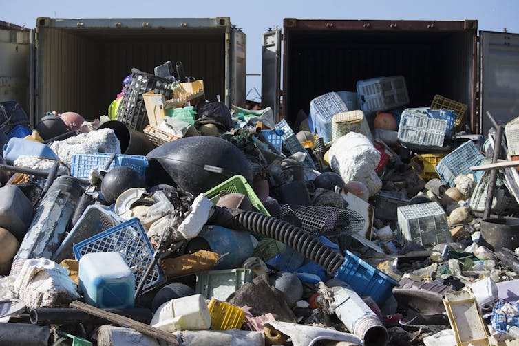 Heaps of debris spill out of shipping containers.