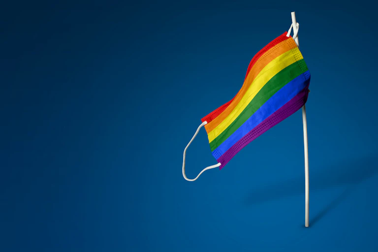 A COVID-19 face mask hangs like a pride flag.