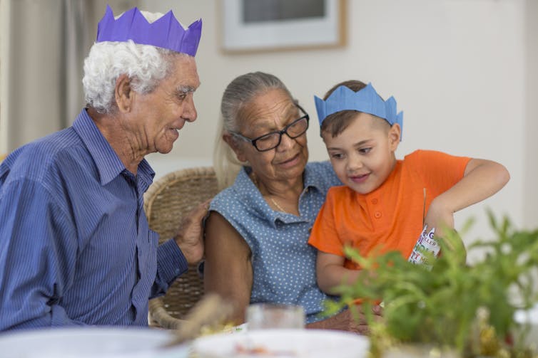 Two elders and a young child at Christmas time.