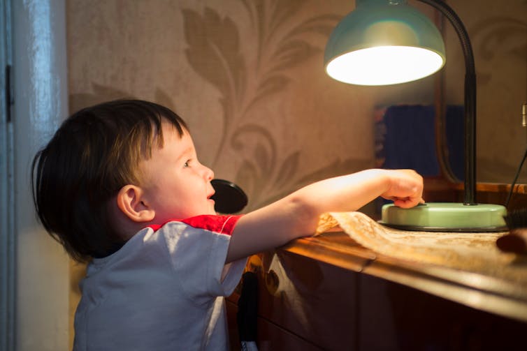 boy turns off lamp