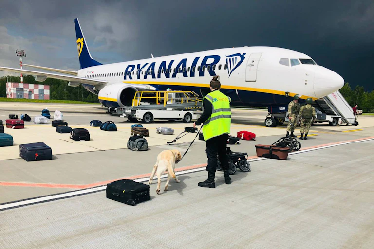 Airport security with a sniffer dog checking the luggage of passengers in front of the Ryanair Boeing 737-8AS (flight FR4978), carrying opposition figure Roman Protasevich.