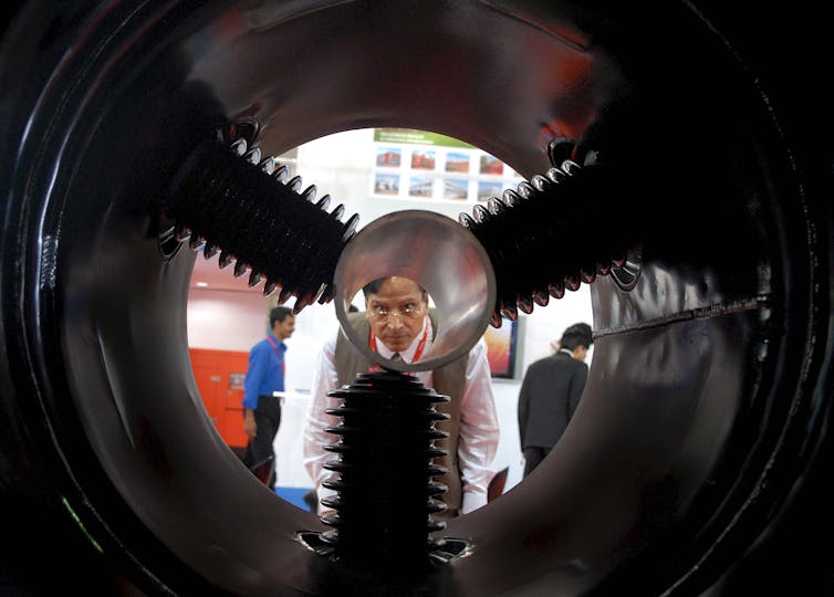 Man at exhibition in India looking at power plant component